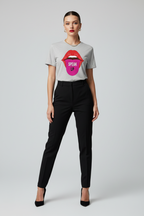 A model wearing a light gray t-shirt with a colorful graphic of red lips and a pink tongue containing the word 'SPEAK' in white, paired with black trousers and black heels, against a light gray background.
