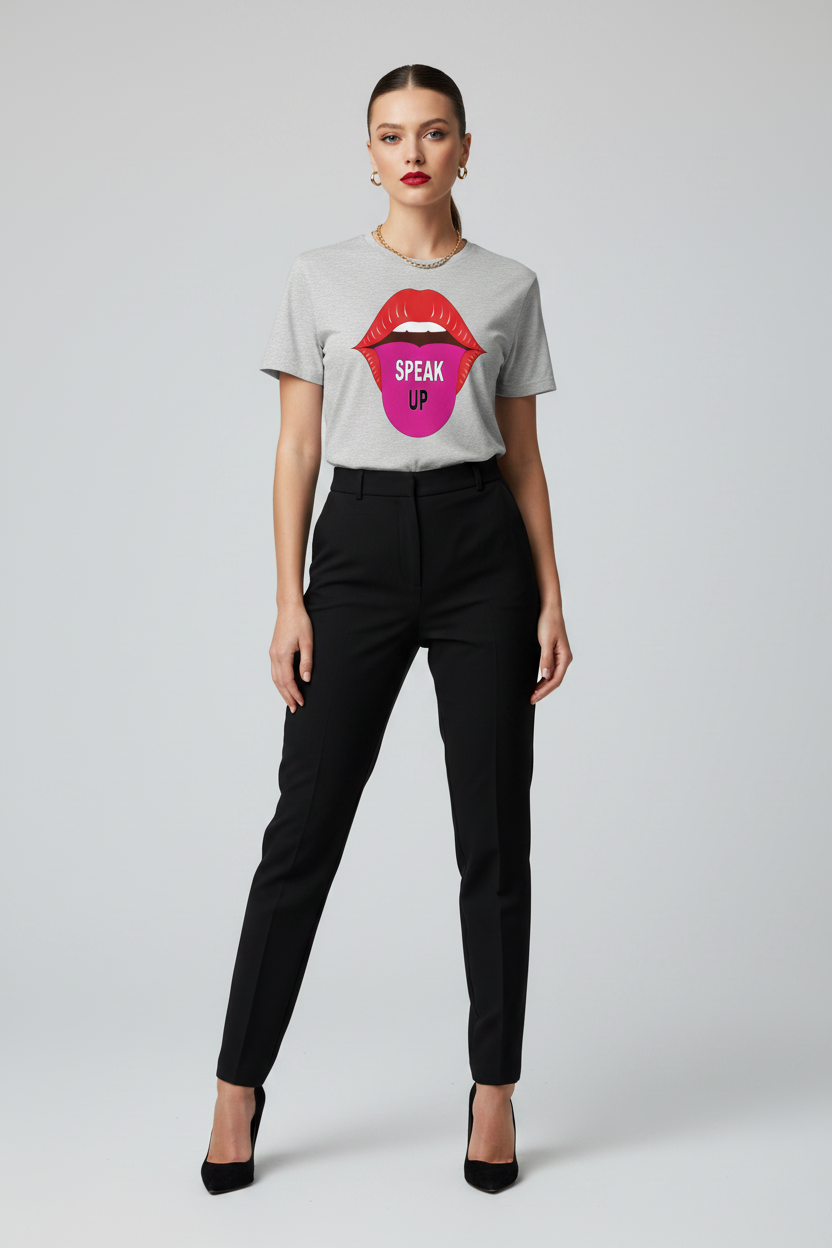 A model wearing a light gray t-shirt with a colorful graphic of red lips and a pink tongue containing the word 'SPEAK' in white, paired with black trousers and black heels, against a light gray background.