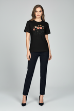 Woman wearing a black t-shirt with floral design and 'LOVE' text, paired with black pants on a light gray background.