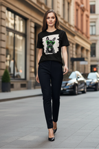 A woman walking down a city street wearing a black graphic t-shirt with a dog print, black pants, and black heels.