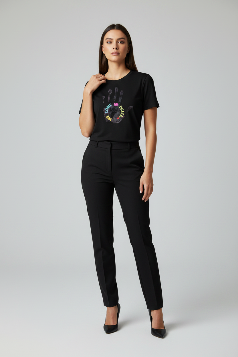 Woman wearing a black t-shirt with a colorful graphic design on a plain background