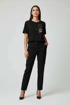 Woman wearing a black t-shirt with a graphic design and black pants on a white background