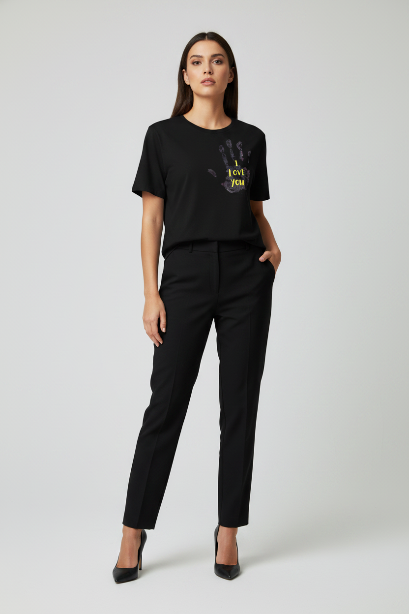 Woman wearing a black t-shirt with a graphic design and black pants on a white background