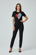 Woman wearing a black t-shirt with a colorful heart design on a plain background