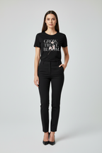 Woman wearing a black t-shirt with text and black pants on a white background