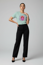 A woman modeling a mint green t-shirt with a graphic of red lips and the words 'I LOVE YOU' in white, paired with black wide-leg trousers and black heels, against a light gray studio background.