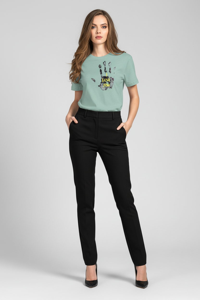 Woman wearing a light green t-shirt with a graphic design and black pants on a white background