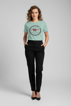 Woman wearing a light green t-shirt with a graphic design on a gray background