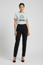 A woman modeling a light blue graphic t-shirt with a cartoon bear and the text 'BONNIE AND CLOWN' paired with black trousers and black heels, against a light gray studio background.