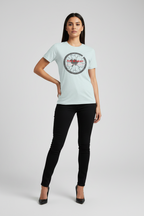 Woman wearing a light blue t-shirt with a logo on a gray background