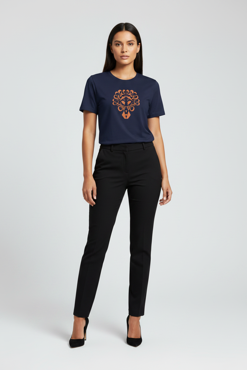 A woman modeling a navy blue short-sleeve t-shirt with a circular orange and gold graphic on the chest, paired with black trousers and black heels, against a light gray studio background.