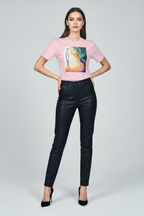 Woman wearing a pink t-shirt with a graphic design and black pants on a white background
