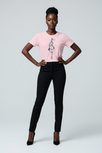 Woman wearing a pink t-shirt with a graphic design and black pants on a light gray background