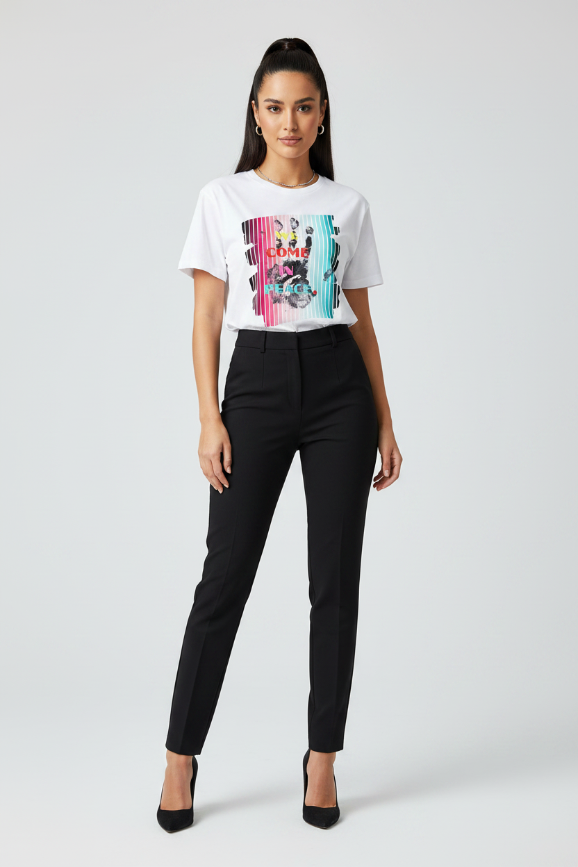 Woman wearing a white t-shirt with a colorful graphic and black pants on a white background