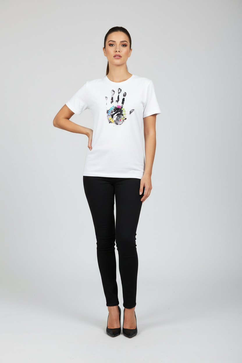 Woman wearing a white t-shirt with a colorful design and black pants on a gray background