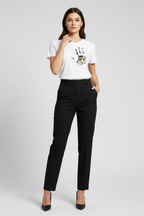 Woman wearing a white t-shirt with a graphic design and black pants on a light gray background
